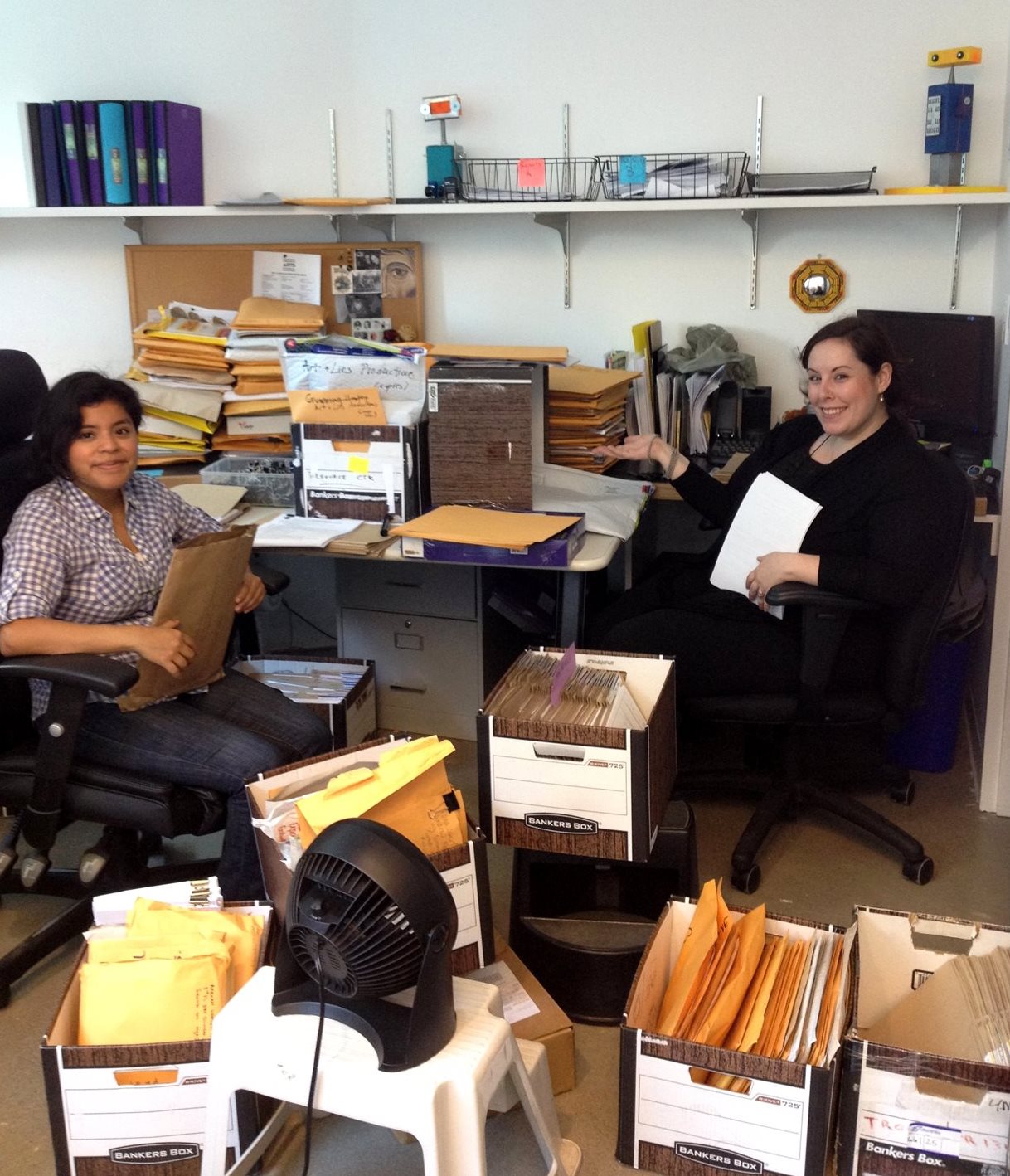 Former grants assistants Norma Garcia and Rachel Feldbloom are surrounded by boxes full of paper applications