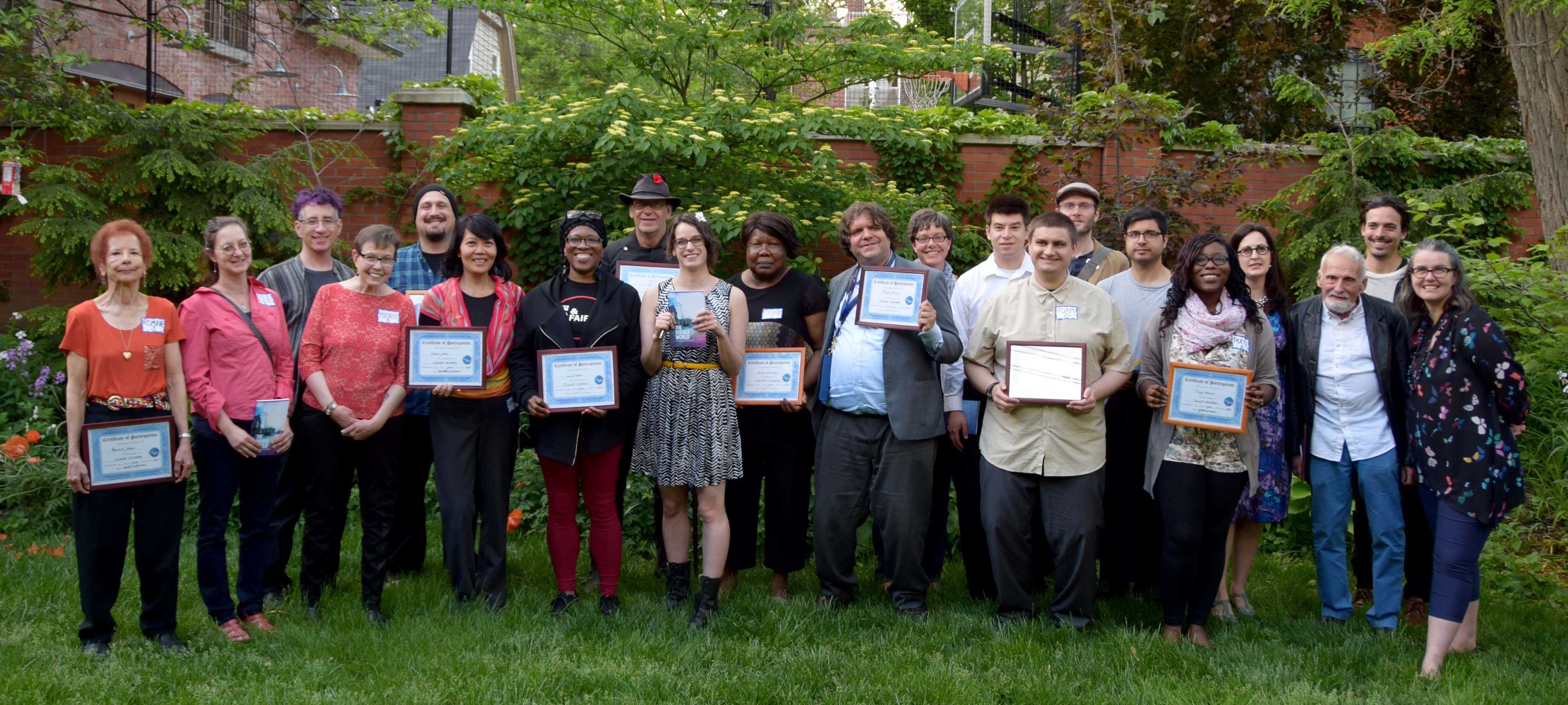 InkWell participants, instructors, and peer support workers stand in a line holding certificates of participation